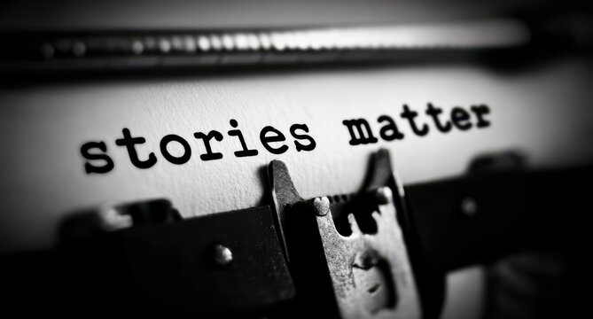 Black and white close up of the phrase stories matter typed onto paper using a vintage mechanical typewriter emphasizing literary importance and communication.