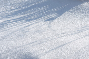 crisp snow crust with deep blue shadow pattern