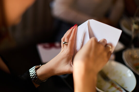 Female hands holding white envelope indoors