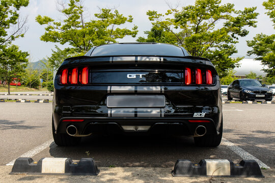 June 5, 2021, Seoul, South Korea - Rear view of a black Ford Mustang GT 6th generation with silver racing stripes parked in an outdoor lot