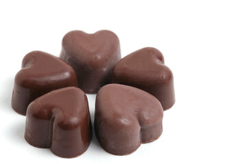 Obraz premium Chocolate candies in shape of hearts on white background.