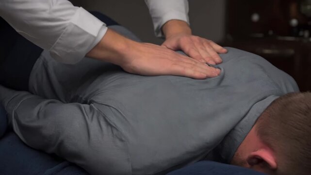 Medium shot of a therapist performing manual spinal decompression therapy on a patient to alleviate chronic back pain naturally