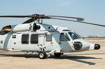 Gray painted modern military transport helicopter stationary on the ground