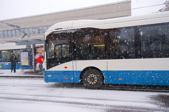 Bus and tram at station named Schwamendingerplatz with passengers on a snowy winter day. Photo taken January 10th, 2026, Zurich, Switzerland.