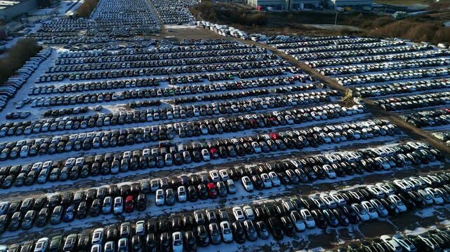 Aerial view of orderly rows of cars creating a geometric pattern at BCA car storage facility, a sea of vehicles under the sky, Corby, Corby, United Kingdom.