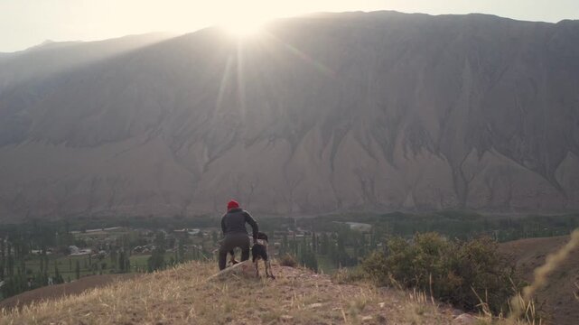 Girl with a dog in the mountains in Kyzyl Oi Village, Kyrgyzstan
