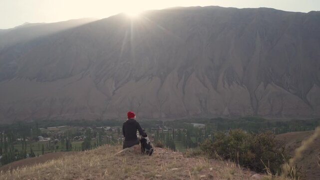 Girl with a dog in the mountains in Kyzyl Oi Village, Kyrgyzstan