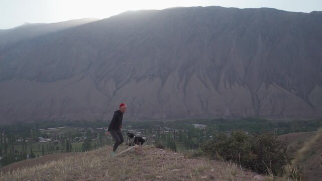 Girl with a dog in the mountains in Kyzyl Oi Village, Kyrgyzstan