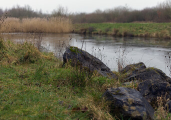Landscape image of some rocks with a lake in the background.