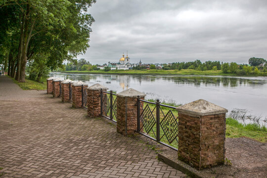 The well-maintained embankment of the Velikaya River with a view of the Spaso-Kazansky Simansky Convent. Ostrov, Pskov Oblast, Russia