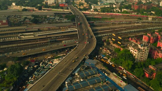 Aerial view of the bridge with moving vehicles above railway tracks and buildings, creating a vibrant urban scene, Howrah, West Bengal, India.