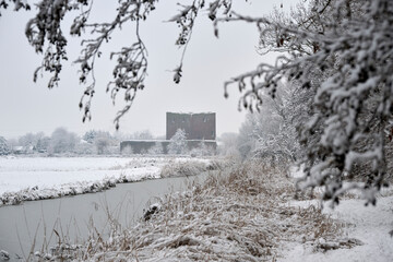 Teylingen Castle in a beautiful snowy landscape, with trees, frozen reeds and ditch