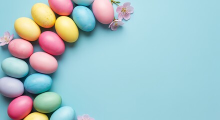 Obraz premium Colorful Easter Eggs Arranged in a Curve with Pink Blossoms on Blue Background