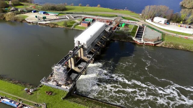 Aerial view of the Colwick Sluice, a captivating structure where water cascades with force, creating a mesmerizing display of nature's power, Colwick, Nottingham, United Kingdom.