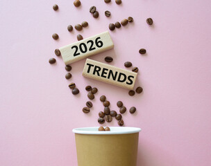2026 Trends symbol. Concept words 2026 Trends on beautiful wooden picture frame. Beautiful pink background with coffee cup and coffee beans. Business and 2026 Trends concept. Copy space.