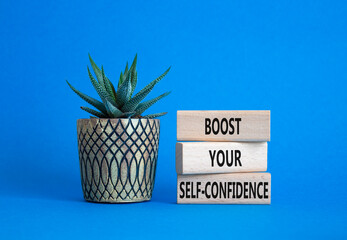 Self-confidence symbol. Concept word Boost your Self-confidence on wooden blocks with succulent. Beautiful blue background. Business lifestyle and Self-confidence concept. Copy space