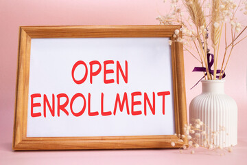 Open Enrollment symbol. Concept words Open Enrollment on beautiful wooden picture frame. Beautiful pink background with flower vase. Business and Open Enrollment concept. Copy space.