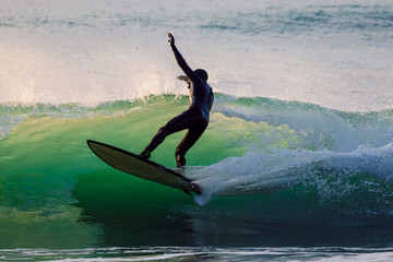 Surfer ride on waves of the ocean, performing various tricks.