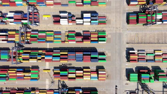 Aerial view of colourful shipping containers, neatly stacked in rows, creating a vibrant, organised pattern at the Port of Felixstowe, Felixstowe, United Kingdom.