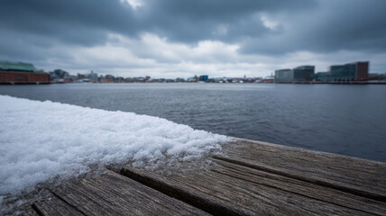 Snow winter pier waterfront city skyline overcast cold moody urban snow dusts wooden pier by waterfront city skyline fades overcast light cold air and quiet mood embrace serene urban harbor scene