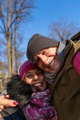 Happy senior couple smiling for a selfie outdoors on a sunny winter day