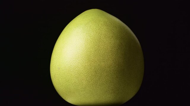 Rotating whole pummelo citrus on black background.
Spinning ripe pomelo fruit against dark backdrop.