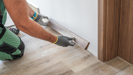 Installing elegant plastic baseboard, showcasing skilled craftsmanship in home improvement and...