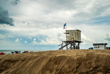 A beach with a lifeguard station and umbrellas