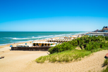 A beach with a lot of beach houses and a lot of people