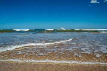 The ocean is calm and the water is a light blue color