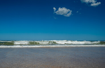 The ocean is calm and the water is a light blue color