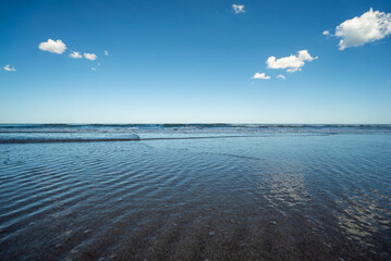 The ocean is calm and the water is a light blue color