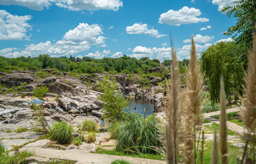 A path leads through a grassy area with a small stream