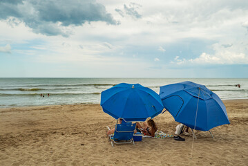 Two blue umbrellas are on the beach