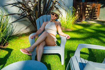 A woman is sitting in a chair in a grassy area