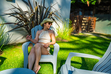 A woman is sitting in a chair in a grassy area