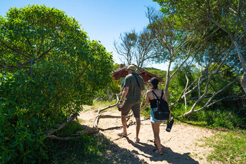 A man and a woman are walking in a forest
