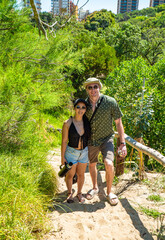 A man and a woman are standing on a path in a forest