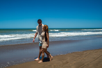 A man and woman walking on the beach
