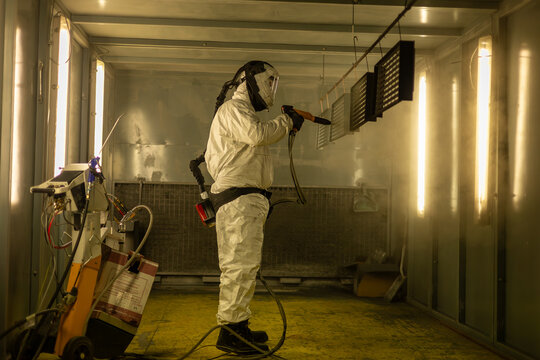 Industrial Powder Coating Process &ndash; Worker Spraying Metal Panels in Protective Suit