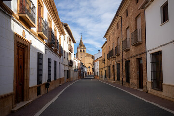 Fototapeta premium Typical street of Villanueva de la Jara, Cuenca, Spain, with the Basilica of Our Lady of the Assumption in the background