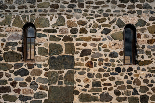 Two small rectangular windows built into a stone building. A window seen on church or monastery buildings.