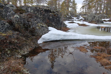 A mountain tundra landscape in Lapland in late spring, with snow still on the ground.