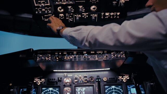 Commercial airplane pilot operating controls in cockpit