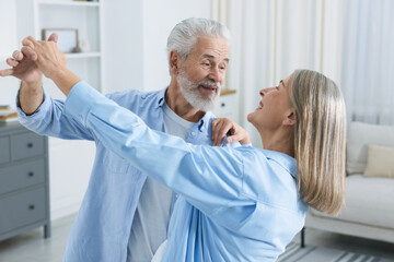 Obraz premium Lovely senior couple dancing together at home