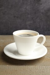 Cup of aromatic coffee on wooden table