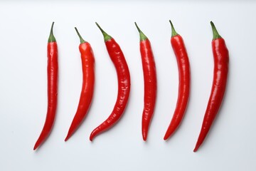 Ripe red chili peppers on white background, flat lay