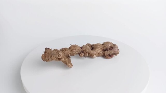 Fresh organic ginger root rotating on white. Raw herbal spice ingredient isolated on background.
