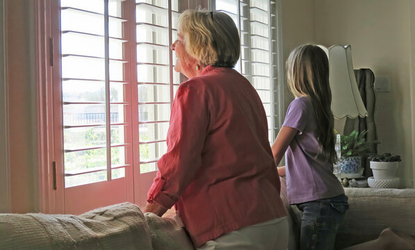 A smiling woman and child peeping through the window