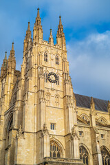 Fototapeta premium Canterbury Cathedral South West tower, also called Dunstan or Oxford Tower, looking golden in the light of a bright December day with blue sky. 